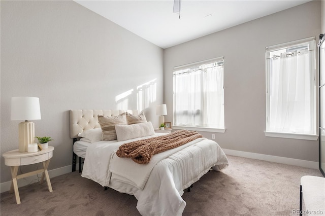 carpeted bedroom with lofted ceiling