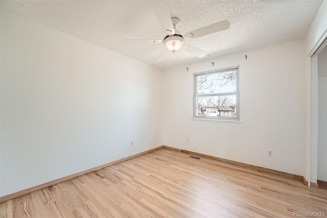 unfurnished bedroom with baseboards, light wood-style floors, visible vents, and a textured ceiling