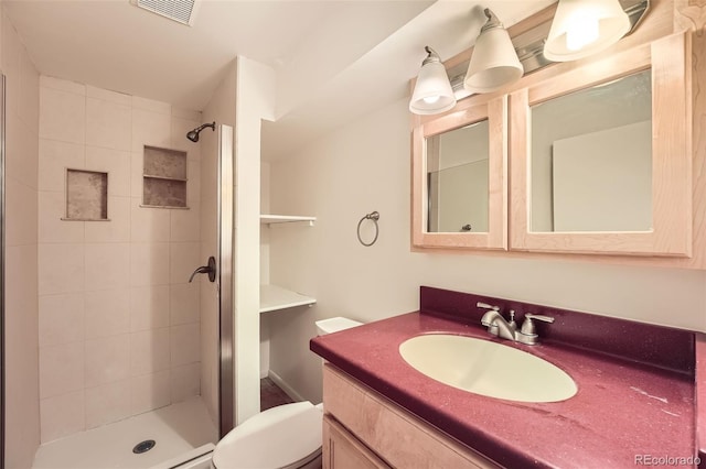 bathroom featuring vanity, toilet, visible vents, and a stall shower