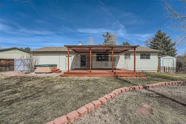 rear view of property featuring fence, a shed, a pergola, a hot tub, and an outdoor structure