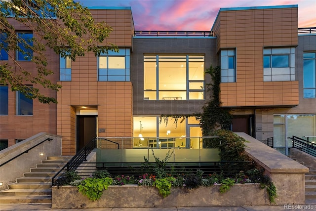 view of front of house featuring brick siding and stairway