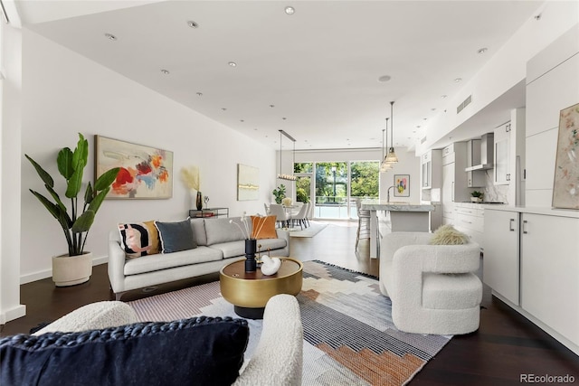 living room featuring recessed lighting, dark wood-style flooring, visible vents, and baseboards