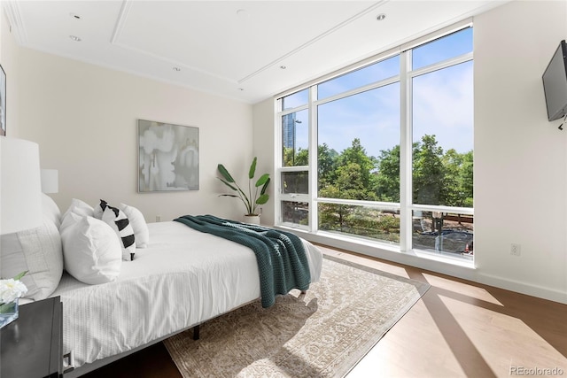 bedroom with wood finished floors, attic access, and baseboards