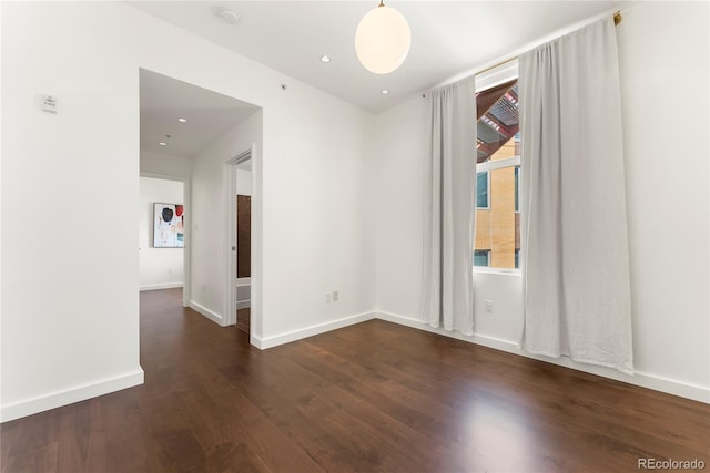 unfurnished room with baseboards, wood finished floors, and recessed lighting