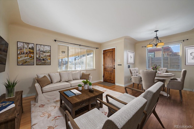 living room featuring hardwood / wood-style flooring, an inviting chandelier, and a wealth of natural light