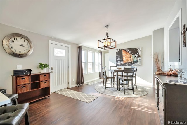 dining area featuring baseboards, a chandelier, and wood finished floors