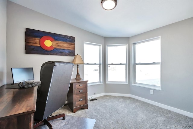 office area featuring carpet floors, a healthy amount of sunlight, visible vents, and baseboards