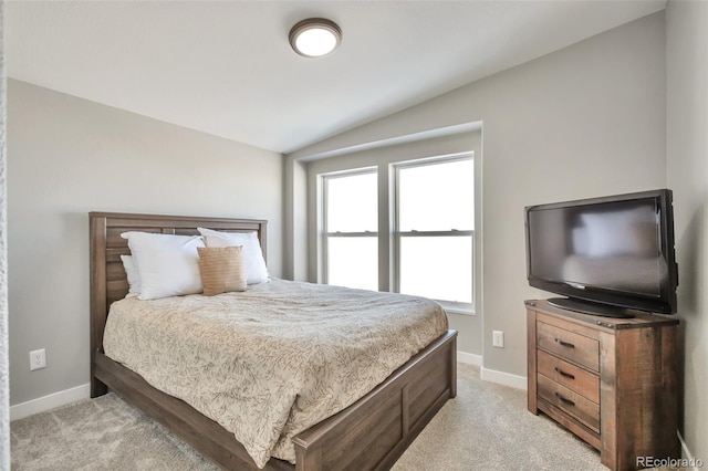 bedroom with lofted ceiling, light colored carpet, and baseboards