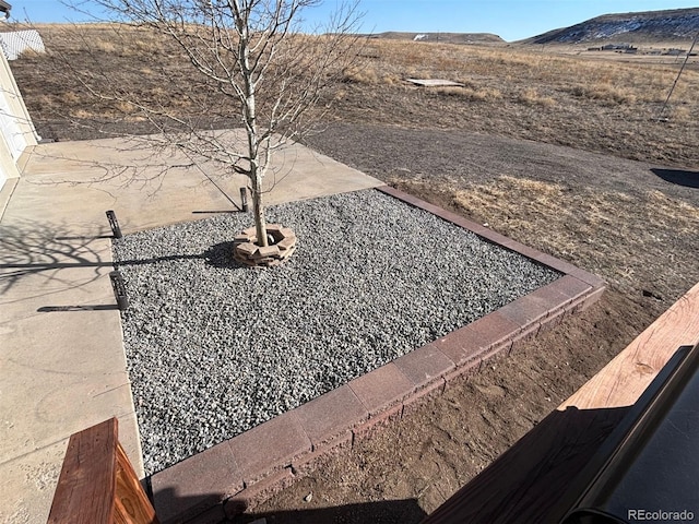 view of yard featuring a patio and a mountain view