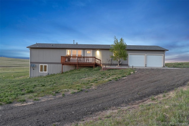 11100 Haskell Creek Rd, Larkspur, CO 80118 - view of front facade featuring a garage, a wooden deck, and driveway