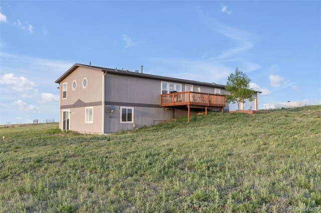 11100 Haskell Creek Rd, Larkspur, CO 80118 - rear view of house featuring a wooden deck and a lawn