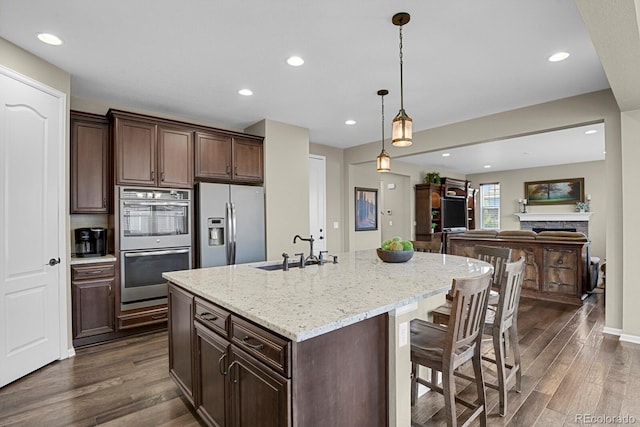 30 S Ider Way, Aurora, CO 80018 - kitchen featuring appliances with stainless steel finishes, a sink, dark wood-style floors, recessed lighting, and light stone countertops
