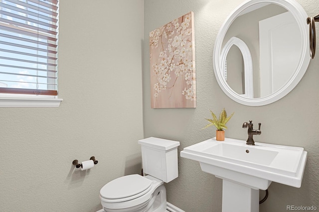 30 S Ider Way, Aurora, CO 80018 - half bath featuring healthy amount of natural light, toilet, a sink, a textured wall, and baseboards