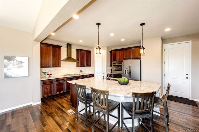 30 S Ider Way, Aurora, CO 80018 - kitchen featuring wall chimney range hood, appliances with stainless steel finishes, dark wood-style flooring, a kitchen breakfast bar, and light stone counters