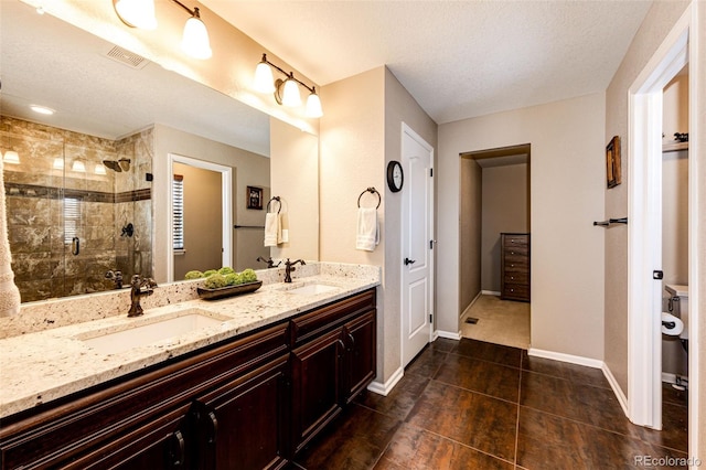 30 S Ider Way, Aurora, CO 80018 - full bathroom with double vanity, a stall shower, tile patterned flooring, and a textured ceiling