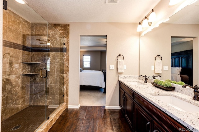 30 S Ider Way, Aurora, CO 80018 - full bath with connected bathroom, double vanity, a shower stall, a textured ceiling, and wood finished floors