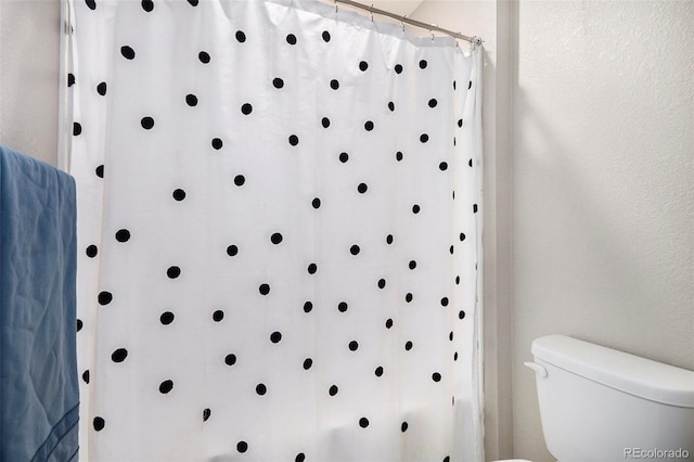 bathroom featuring toilet and a shower with shower curtain