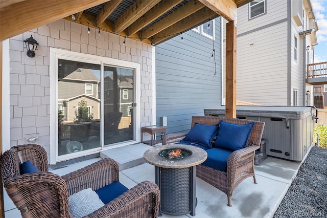 view of patio / terrace with an outdoor fire pit and a hot tub