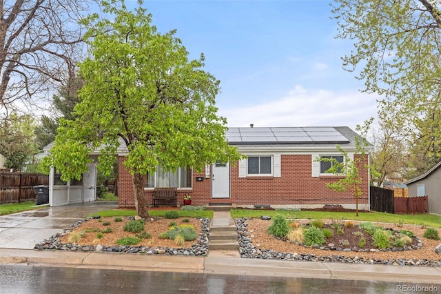 3379 W Wagon Trail Dr, Englewood, CO 80110 - single story home featuring brick siding, fence, solar panels, concrete driveway, and a shingled roof