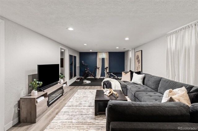 3379 W Wagon Trail Dr, Englewood, CO 80110 - living area with light wood-type flooring, baseboards, recessed lighting, and a textured ceiling