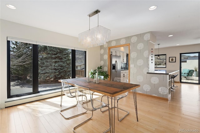 330 Ptarmigan St, Golden, CO 80403 - dining space featuring wallpapered walls, baseboard heating, a chandelier, baseboards, and light wood-type flooring