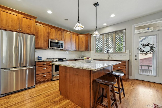3240 Spruce St, Denver, CO 80238 - kitchen featuring stainless steel appliances, light wood finished floors, tasteful backsplash, a kitchen island, and brown cabinets