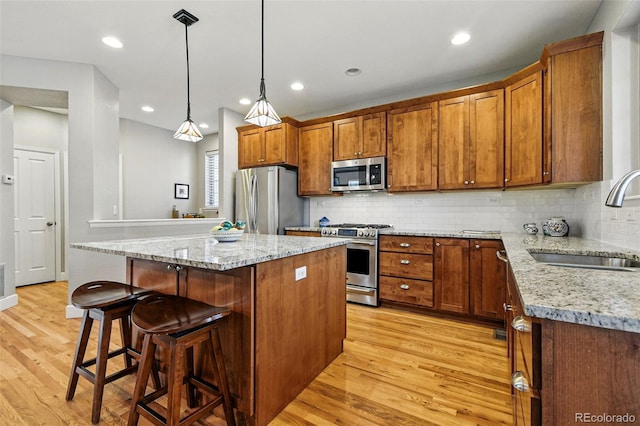 3240 Spruce St, Denver, CO 80238 - kitchen featuring stainless steel appliances, a sink, light wood-style floors, brown cabinets, and recessed lighting