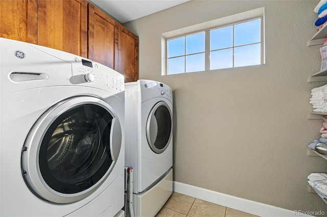 3240 Spruce St, Denver, CO 80238 - clothes washing area featuring cabinet space, independent washer and dryer, light tile patterned floors, and baseboards