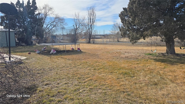 view of yard featuring a trampoline and a rural view