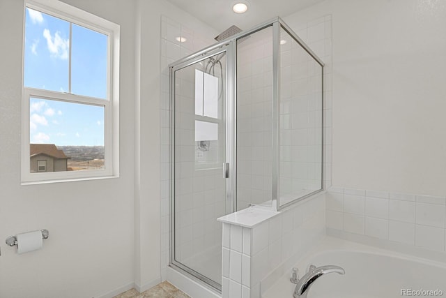 bathroom featuring a stall shower, baseboards, and a garden tub