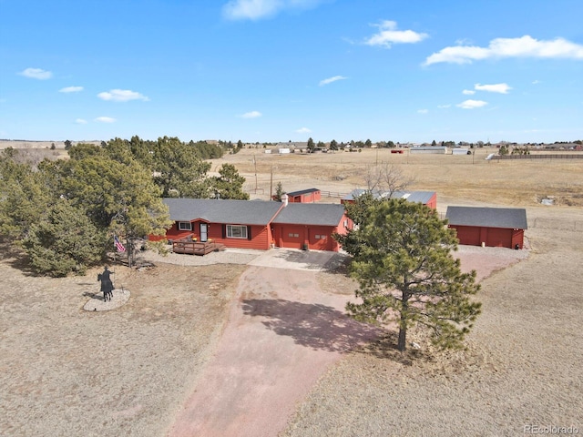 view of front of home with a garage and a rural view