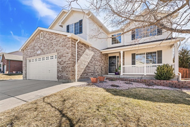 traditional-style home featuring driveway, covered porch, an attached garage, a front yard, and brick siding