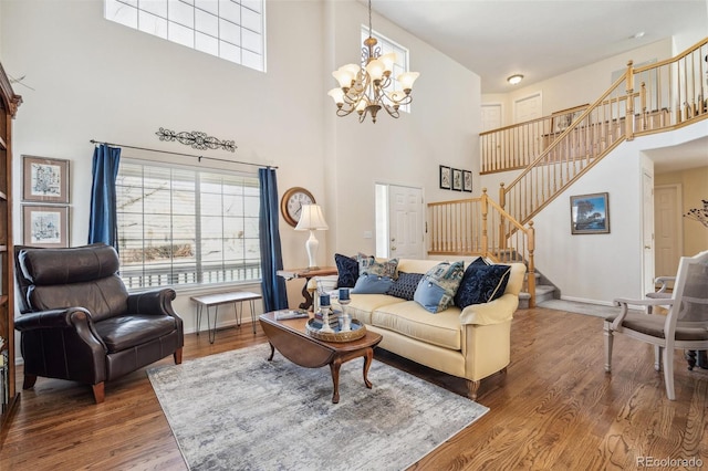 living area featuring stairway, a notable chandelier, and wood finished floors