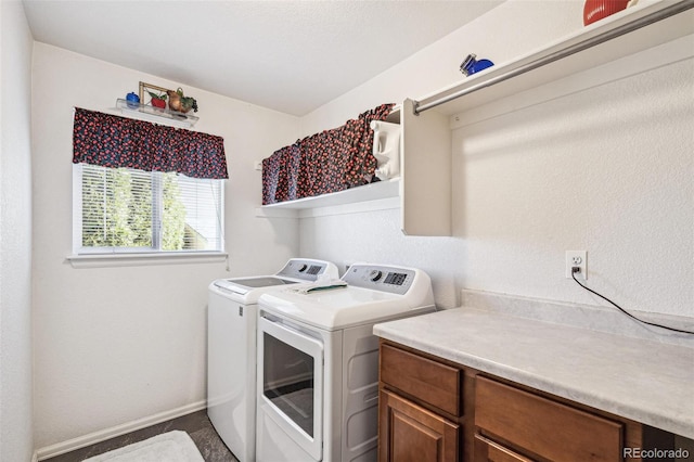 clothes washing area with separate washer and dryer and baseboards