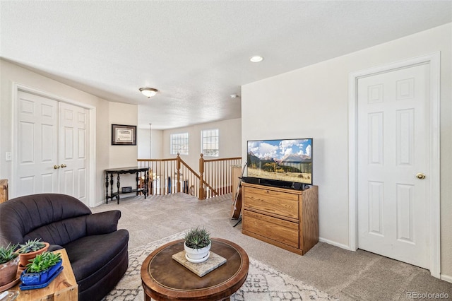 living room with baseboards, carpet floors, and a textured ceiling