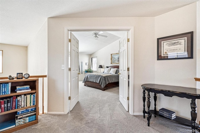 hall featuring vaulted ceiling, baseboards, and carpet floors