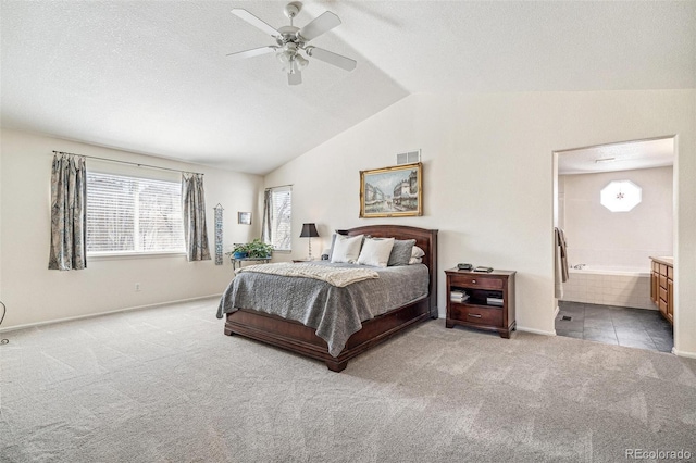 carpeted bedroom featuring visible vents, connected bathroom, a textured ceiling, and lofted ceiling