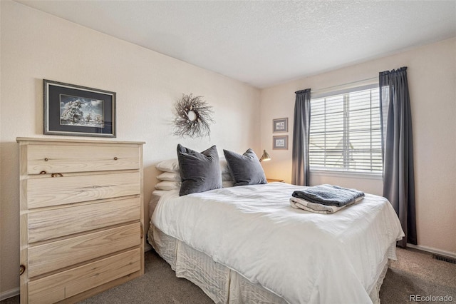 bedroom featuring carpet flooring, baseboards, visible vents, and a textured ceiling