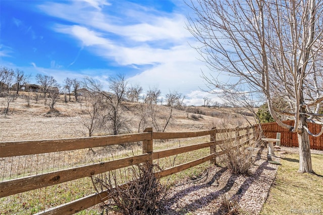 view of yard featuring a rural view and fence