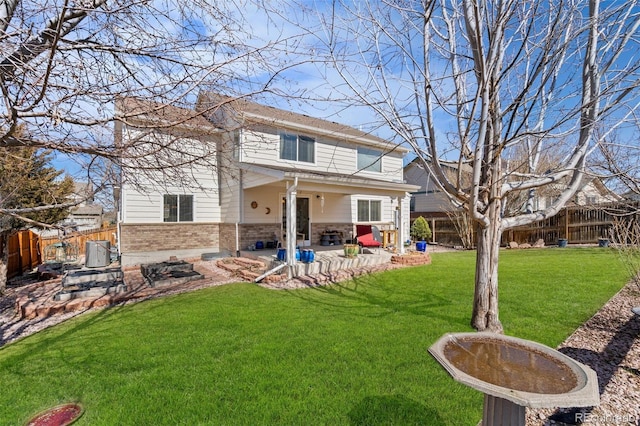 back of property with a patio, a yard, a fenced backyard, and brick siding