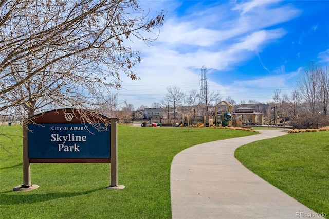 view of property's community with playground community and a yard