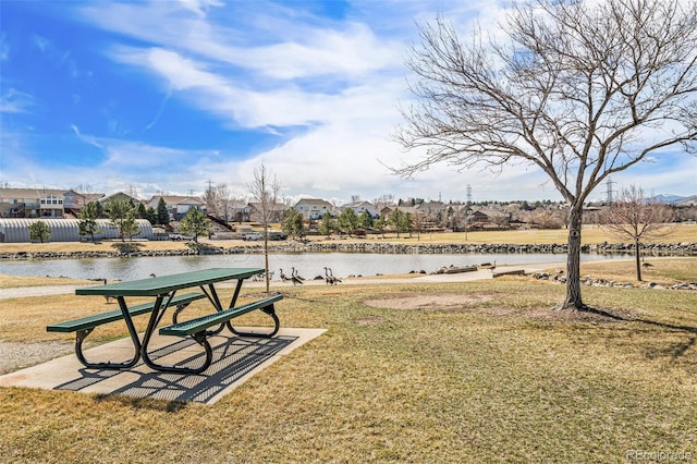 view of home's community featuring a residential view, a lawn, a water view, and fence