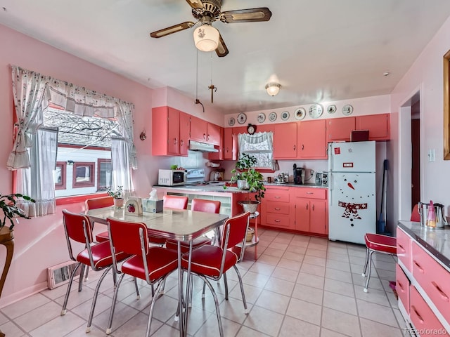 kitchen featuring light tile patterned floors, white appliances, and ceiling fan