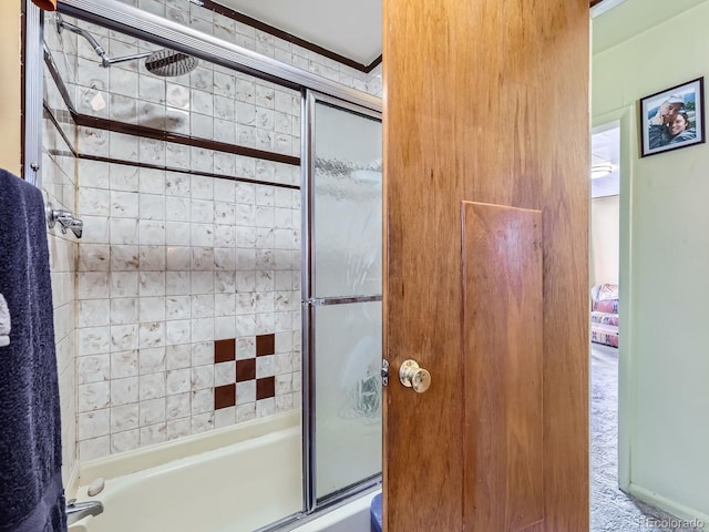 bathroom with bath / shower combo with glass door