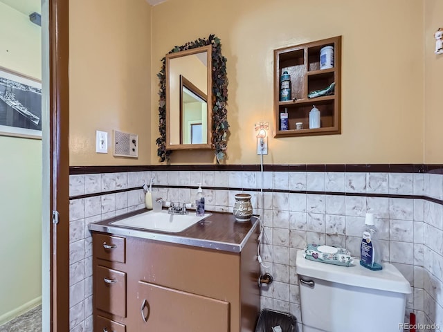 bathroom featuring vanity, tile walls, and toilet