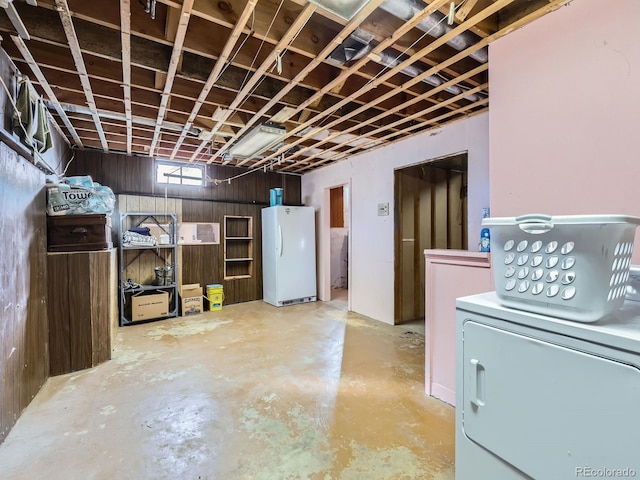 basement featuring white refrigerator and washer / clothes dryer