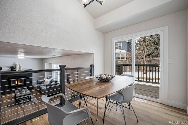 dining space with a notable chandelier, wood-type flooring, and a textured ceiling