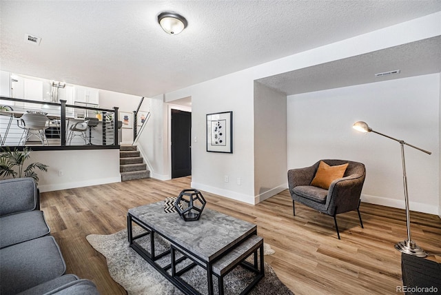 living room featuring light hardwood / wood-style flooring and a textured ceiling