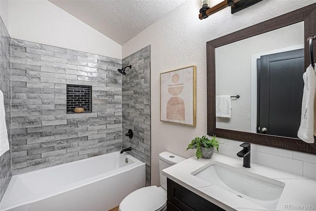 full bathroom featuring lofted ceiling, vanity, a textured ceiling, tiled shower / bath, and toilet