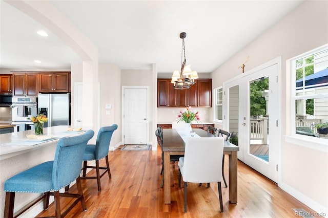6032 Umber St, Arvada, CO 80403 - dining area with light wood-type flooring, a chandelier, baseboards, arched walkways, and recessed lighting
